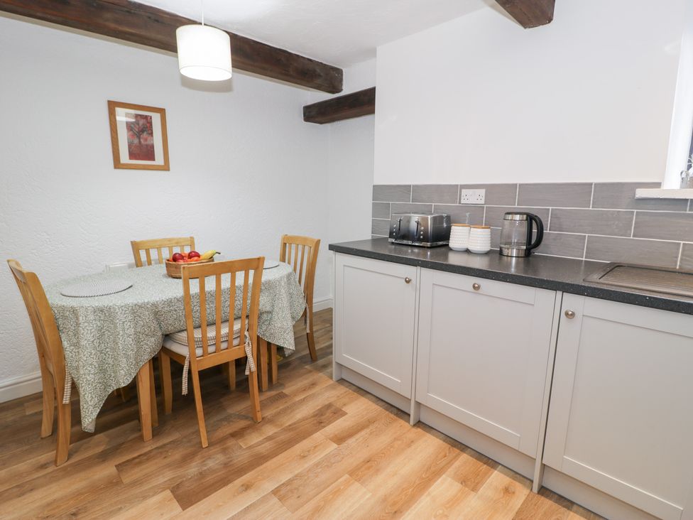 A kitchen with a dining table and appliances at Ivy Cottage in Abergele