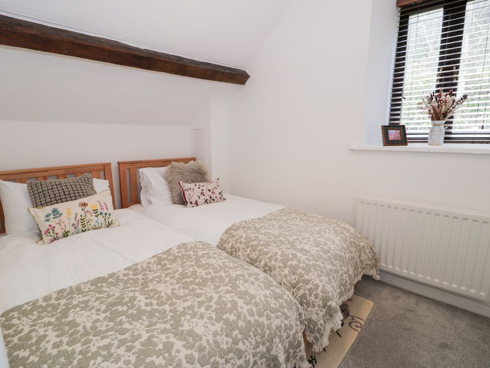 A bedroom with two beds and a window at Ivy Cottage in Abergele