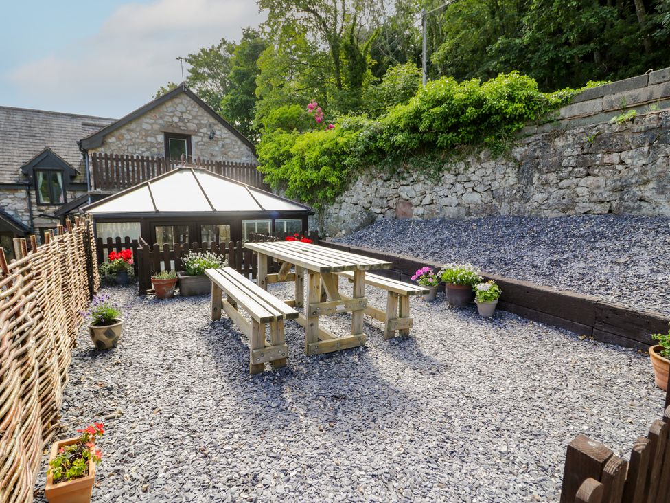 An outdoor area with tables and flower pots at Ivy Cottage in Abergele