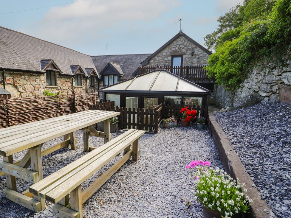 An outdoor area with tables and flower pots at Ivy Cottage in Abergele