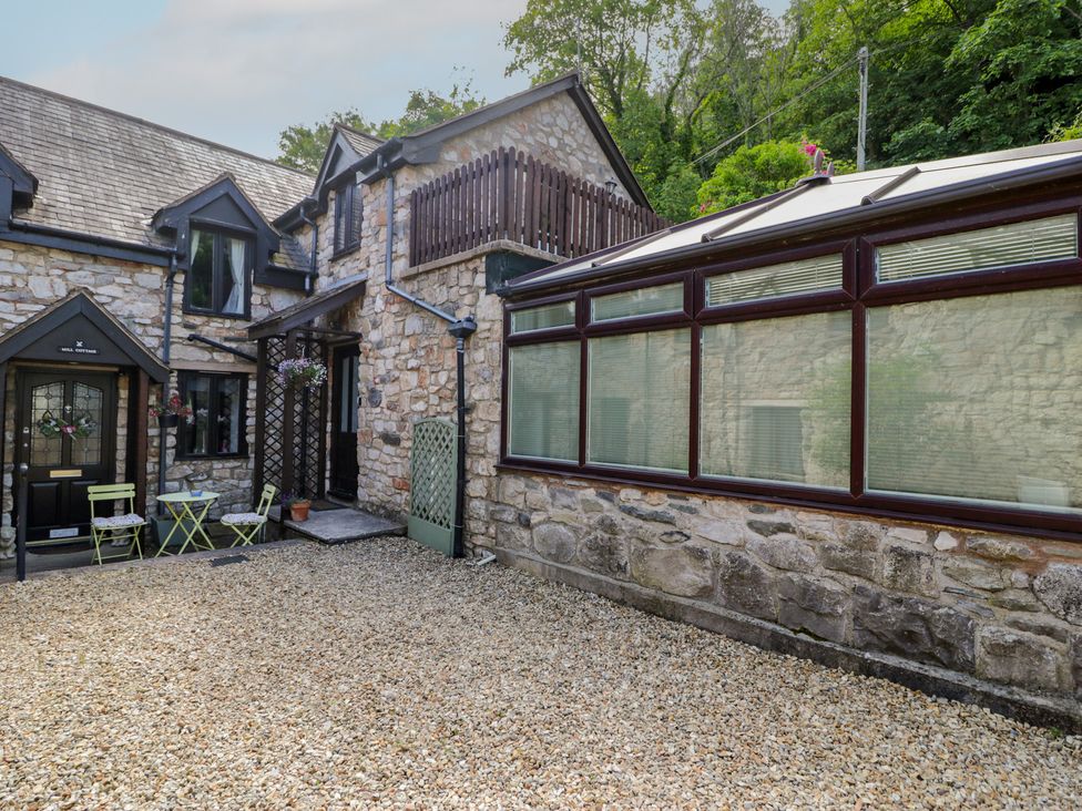An outdoor area with a stone house and gravel at Ivy Cottage in Abergele