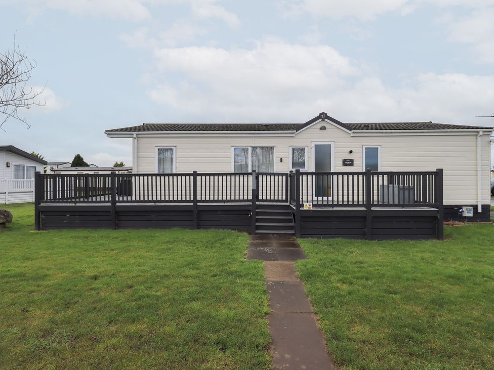 A modular home with a deck and grass area at Lily's Lodge in Morecambe
