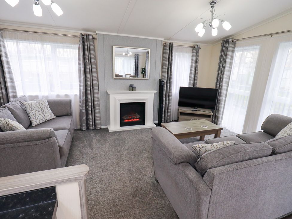 A living room with a sofa and television at Lily's Lodge in Morecambe