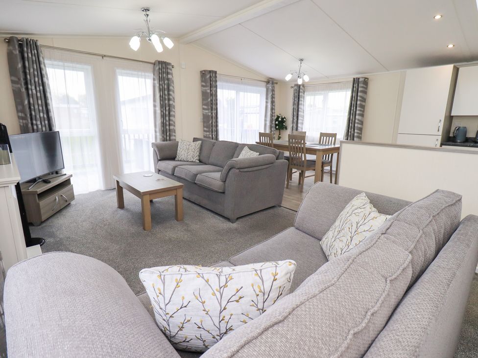 A living room with a sofa and dining area at Lily's Lodge in Morecambe