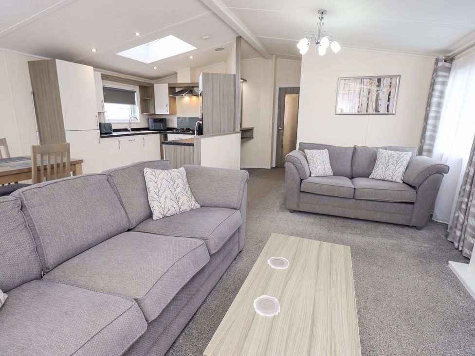 A living room with sofas and a coffee table at Lily's Lodge in Morecambe