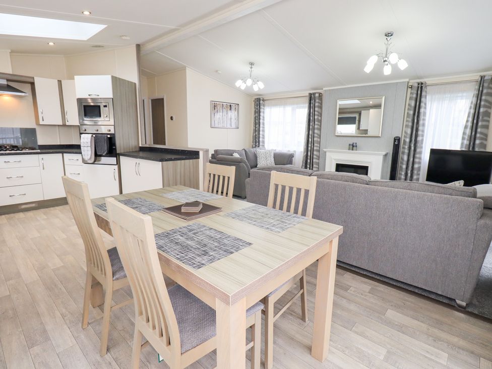 A living room with a dining table and sofa at Lily's Lodge in Morecambe