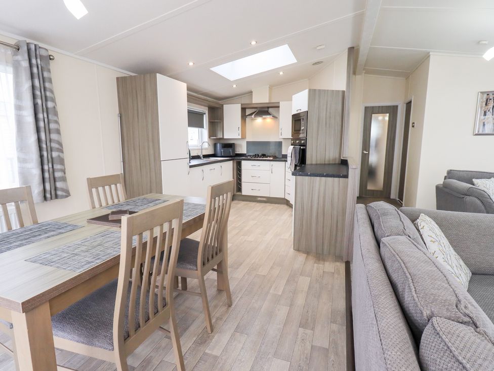 A kitchen and dining area with furniture at Lily's Lodge in Morecambe