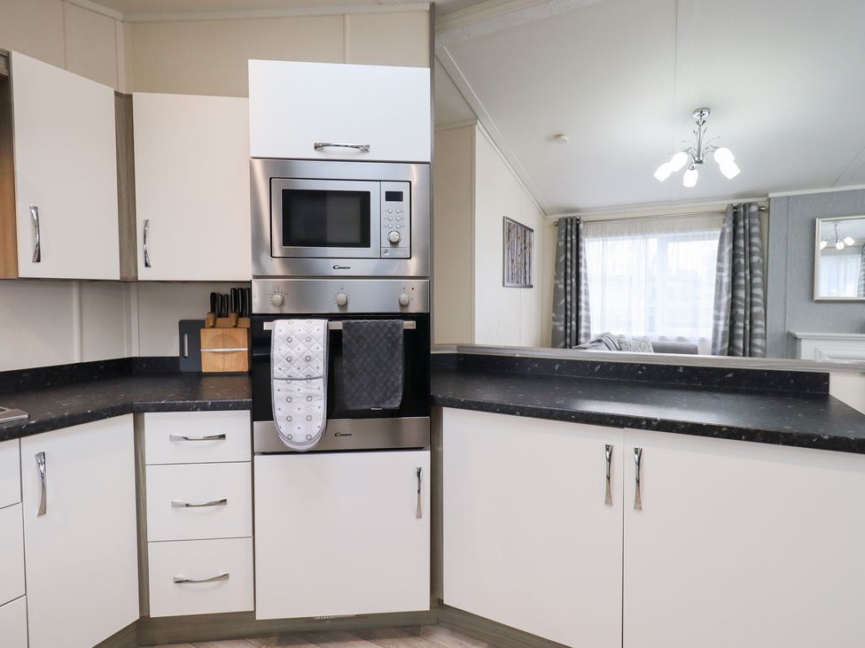 A kitchen with oven and microwave at Lily's Lodge in Morecambe