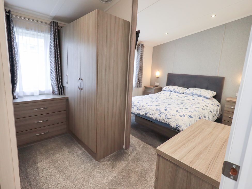 A bedroom with a double bed and wardrobe at Lily's Lodge in Morecambe