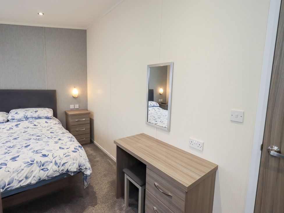 A bedroom with a bed and desk at Lily's Lodge in Morecambe