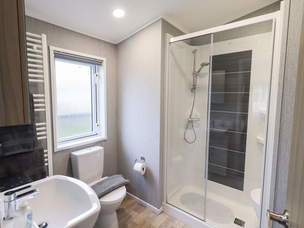 A bathroom with a shower, toilet and sink at Lily's Lodge in Morecambe
