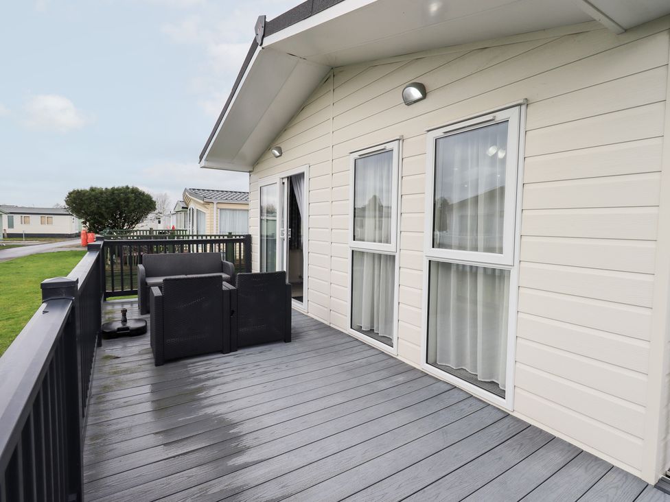 An outdoor area with a couch and windows at Lily's Lodge in Morecambe