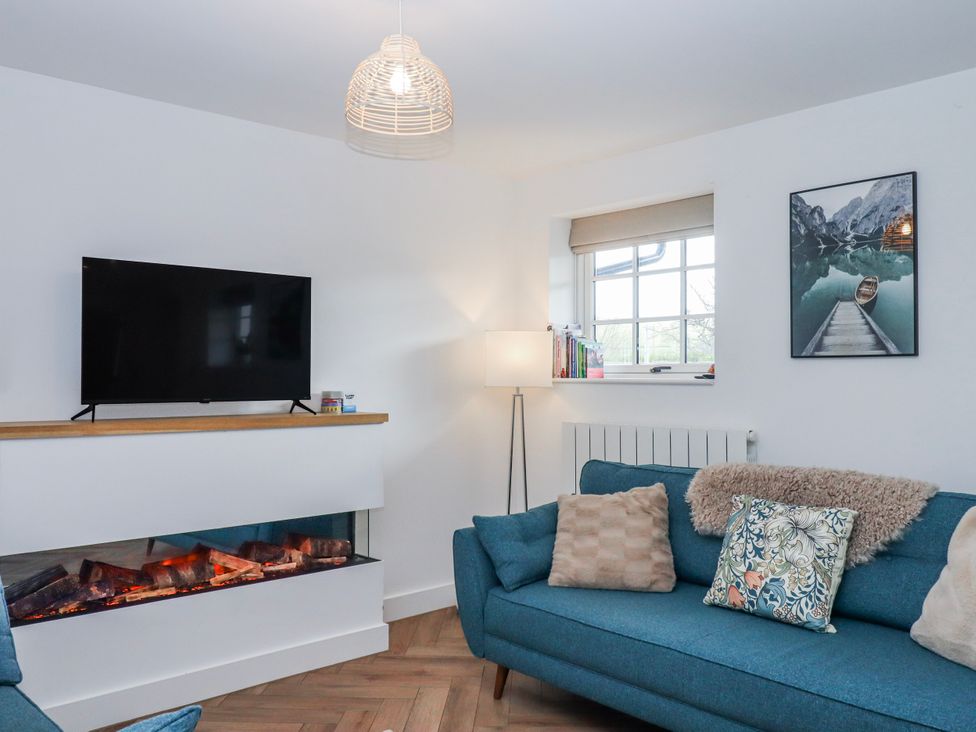 A living room with a television, sofa and fireplace at Shamrock in Exeter