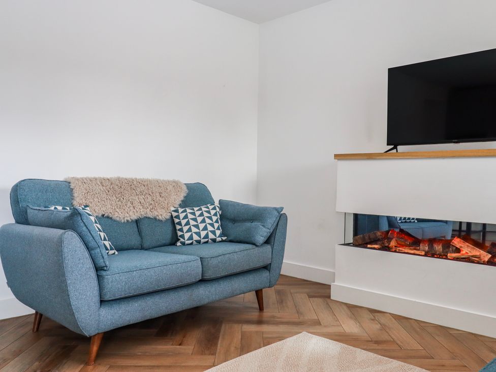 A living room with a sofa and a television at Shamrock in Exeter