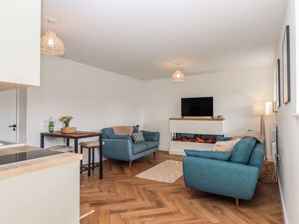 A living room with sofas and a television at Shamrock in Exeter