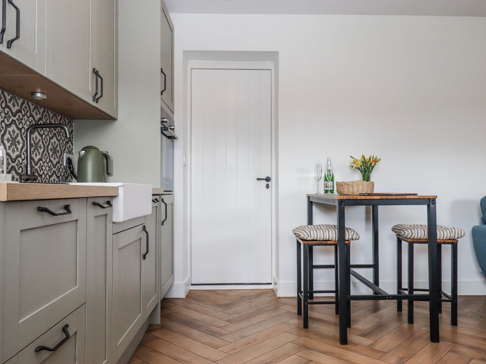 A kitchen with cabinets and a table at Shamrock in Exeter