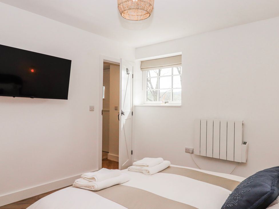A bedroom with a television and towels on the bed at Shamrock in Exeter