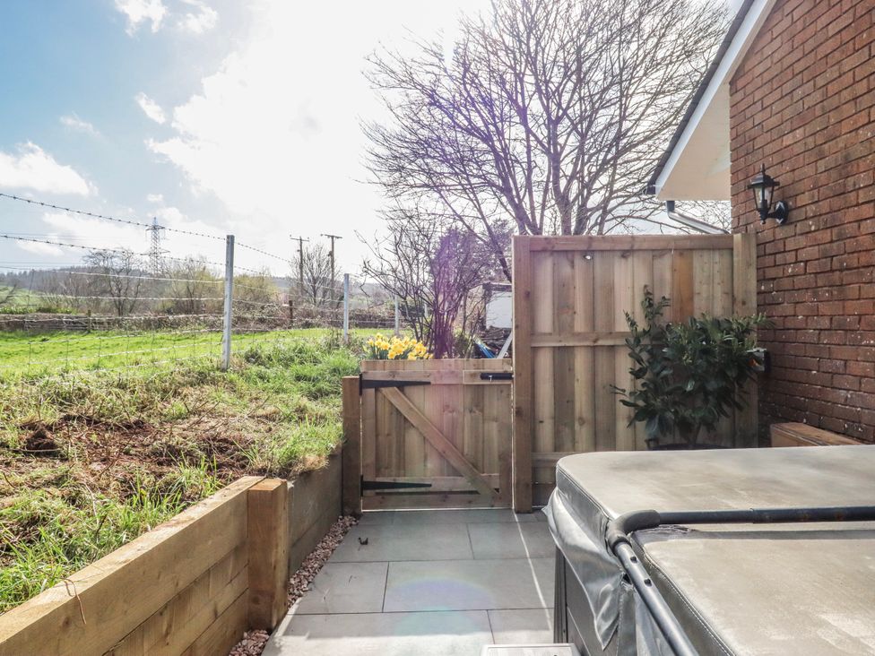 A garden with a hot tub and gate at Shamrock in Exeter