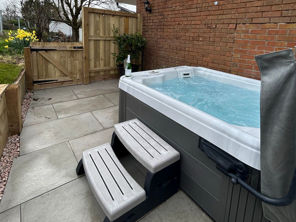 An outdoor area with a hot tub and steps at Shamrock in Stoke Canon