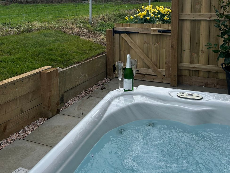 An outdoor area with a hot tub and a bottle near a fence at Shamrock Stoke Canon