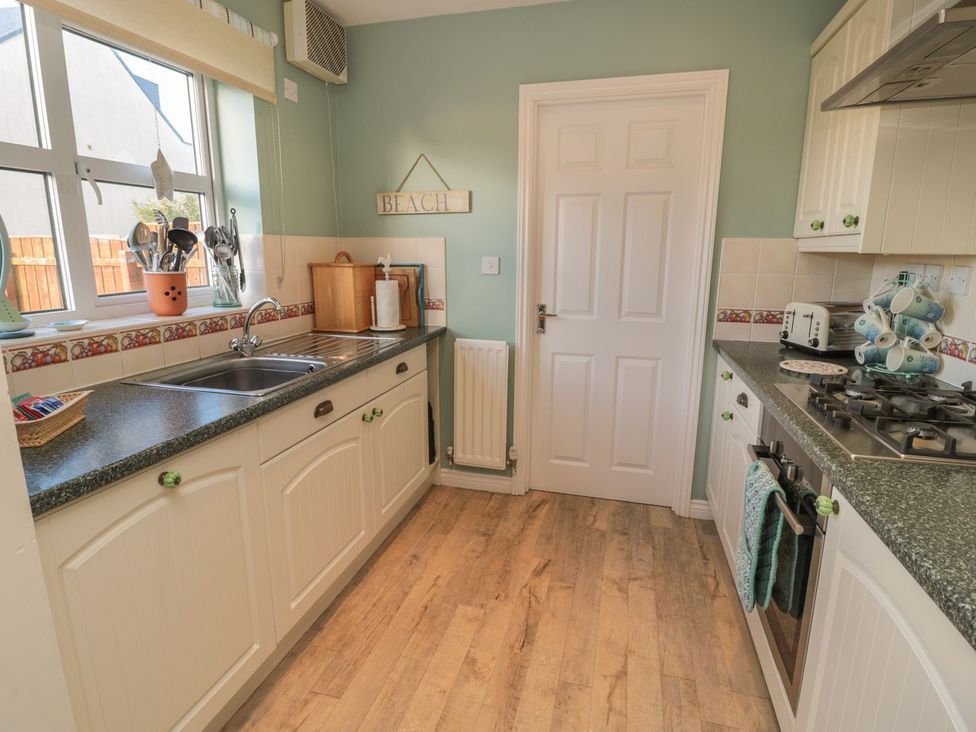 A kitchen with cabinets and a sink at Sandy Cove in Chathill
