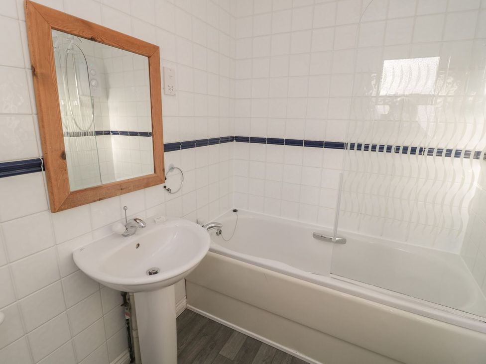 A bathroom with a bathtub and sink at Sandy Cove in Chathill