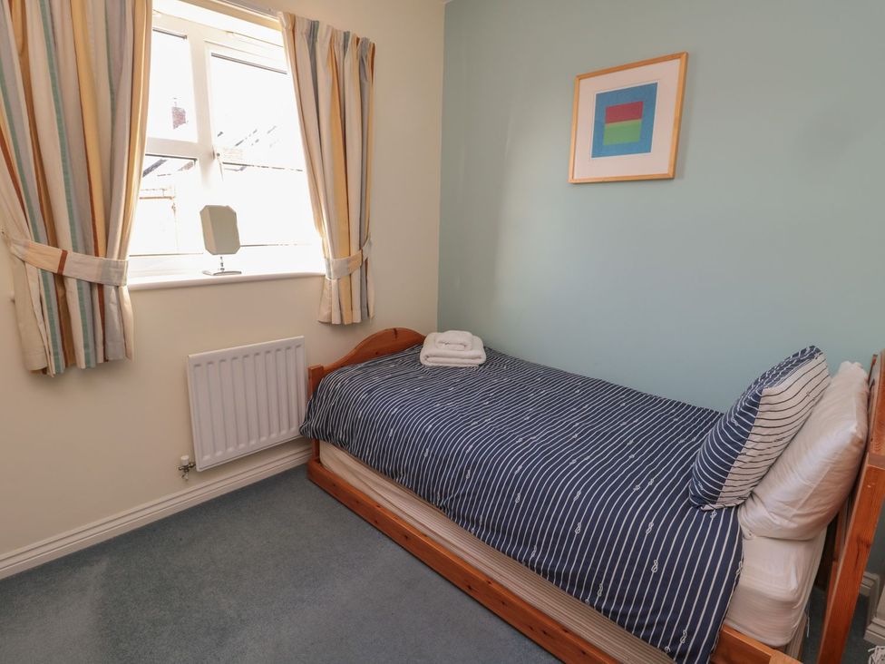 A bedroom with a single bed and window at Sandy Cove in Chathill