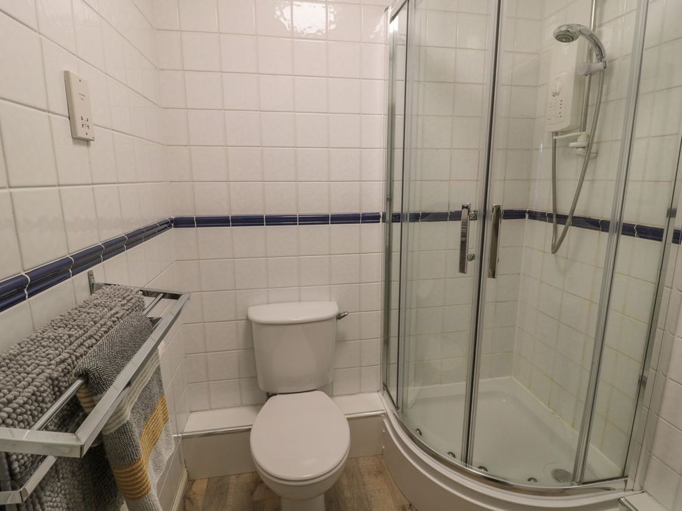 A bathroom with a shower and toilet at Sandy Cove in Chathill