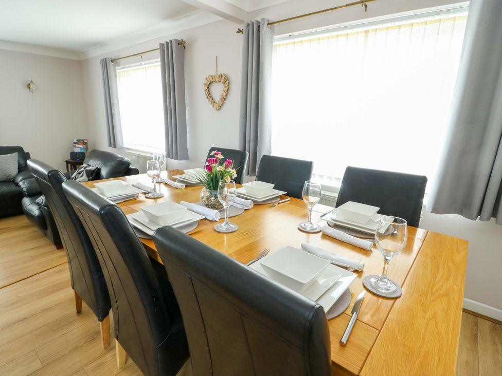 A dining room with a table and chairs at Min Y Cae