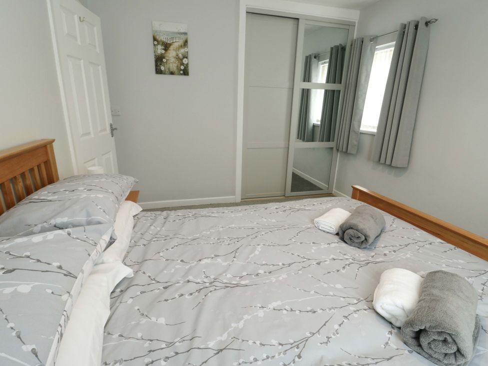 A bedroom with a bed and towels at Min Y Cae