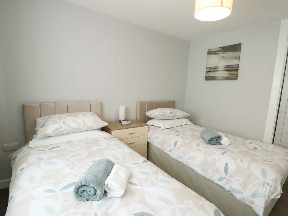A bedroom with two single beds and a bedside table at Min Y Cae 