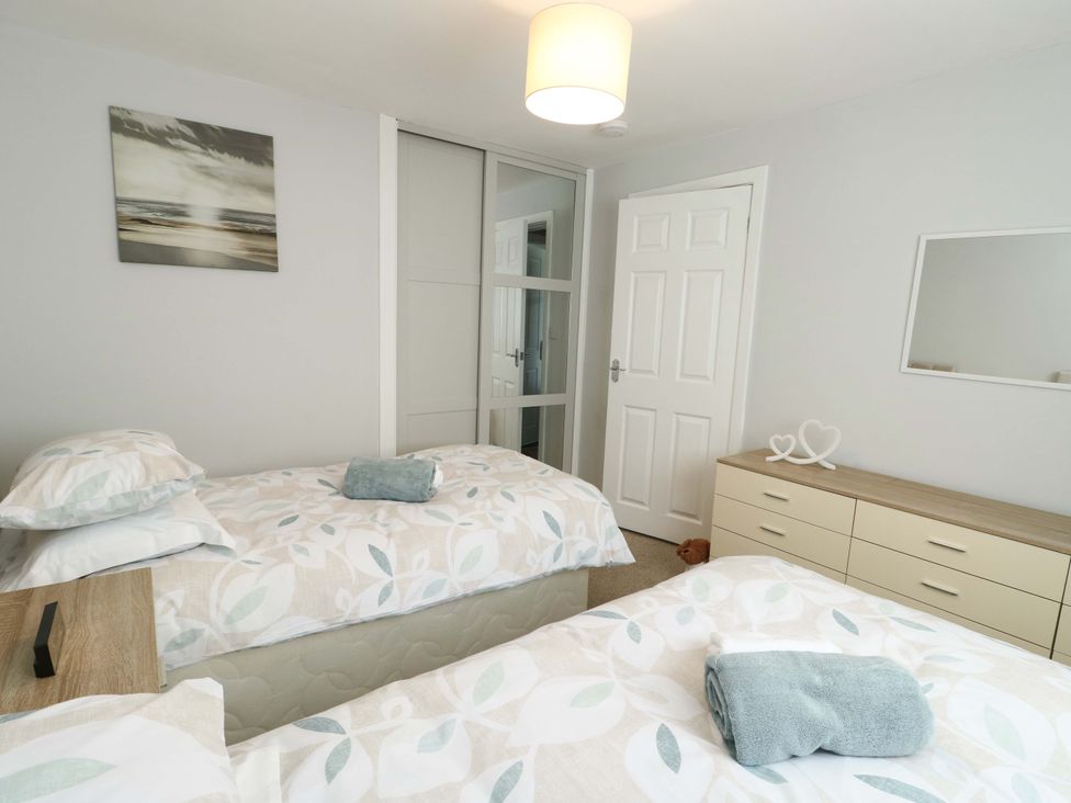 A bedroom with two beds and a dresser at Min Y Cae