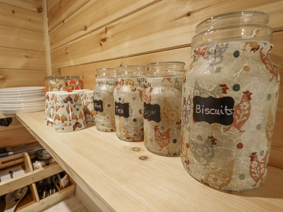 A kitchen shelf with jars for tea, coffee, sugar, and biscuits at Mardi Gras in Wisbech