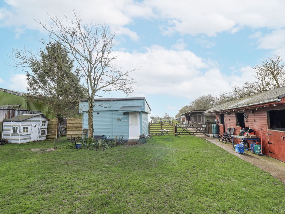 An outdoor area with a shed, barn and tree at Mardi Gras in Wisbech