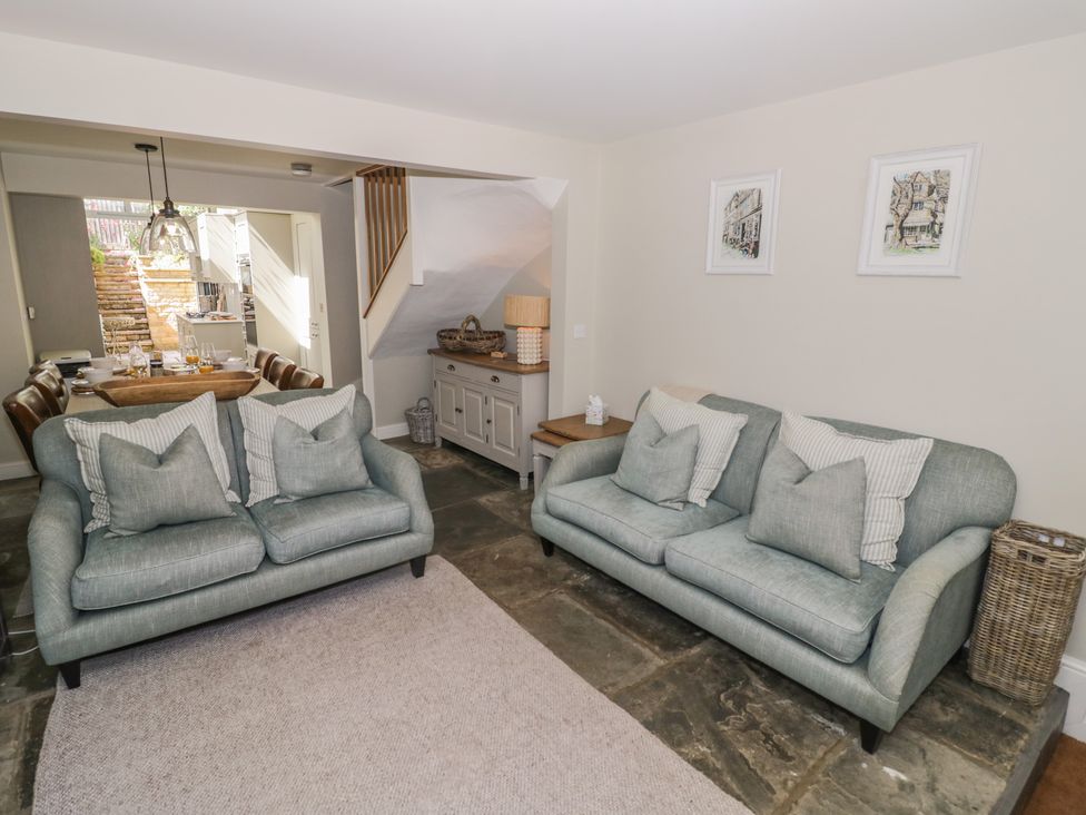 A living room with sofas and a dining area visible at Tea Tree Cottage in Chipping Campden