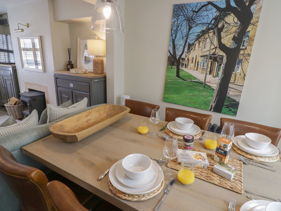 A dining room with a table set for a meal at Tea Tree Cottage in Chipping Campden
