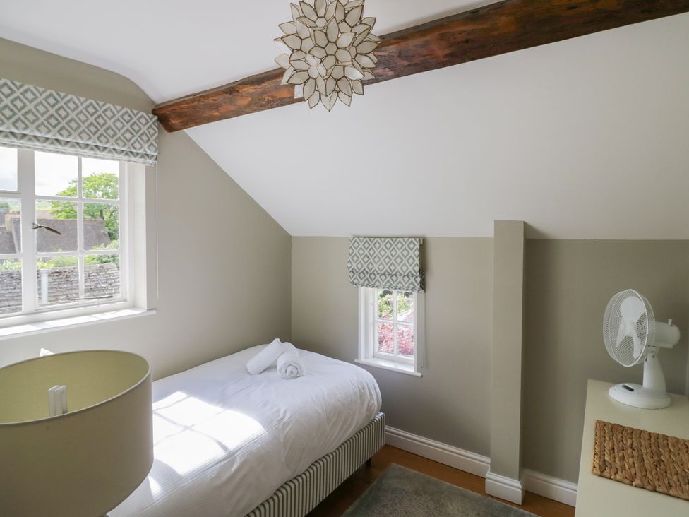 A bedroom with a bed and lamp at Tea Tree Cottage in Chipping Campden