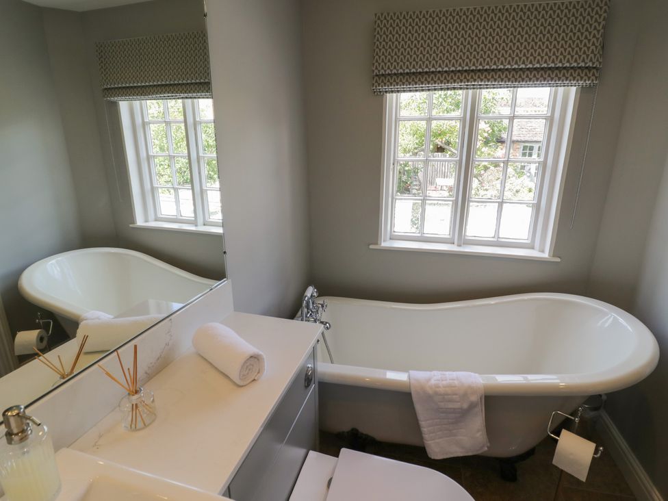A bathroom featuring a bathtub and a washbasin at Tea Tree Cottage in Chipping Campden