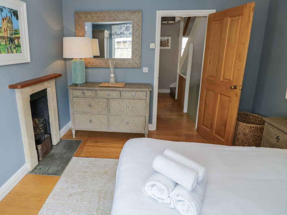 A bedroom with a bed and dresser at Tea Tree Cottage in Chipping Campden