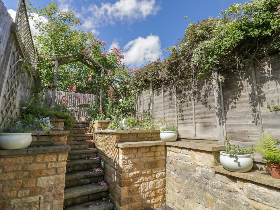 A garden with stairs and potted plants at Tea Tree Cottage in Chipping Campden