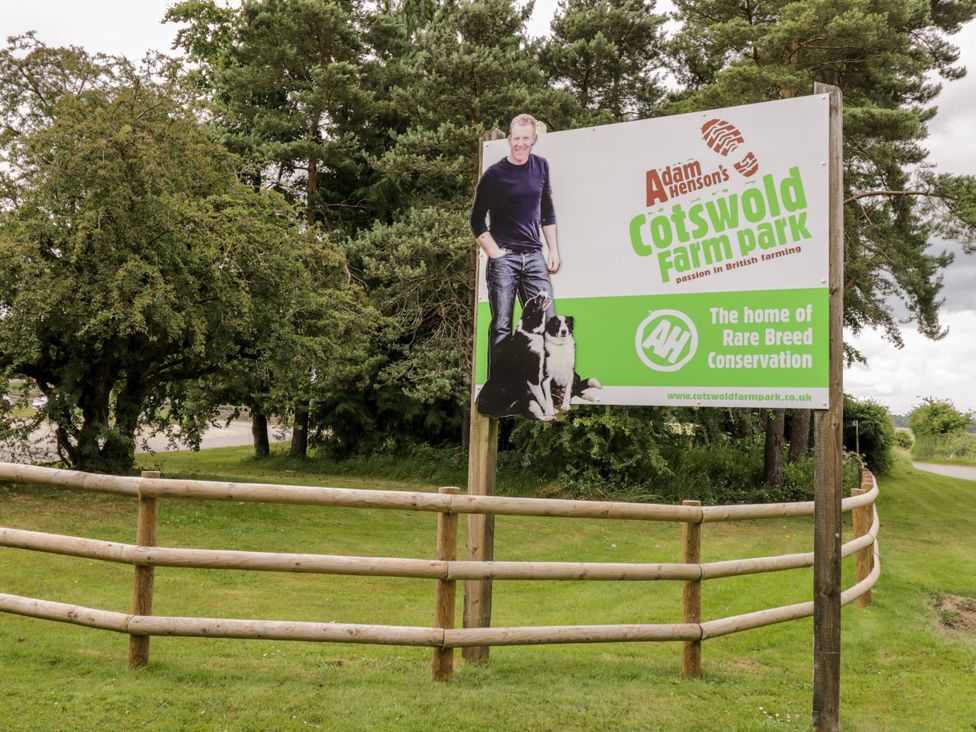 A sign for Cotswold Farm Park with a fence and trees nearby at Tea Tree Cottage, Chipping Campden