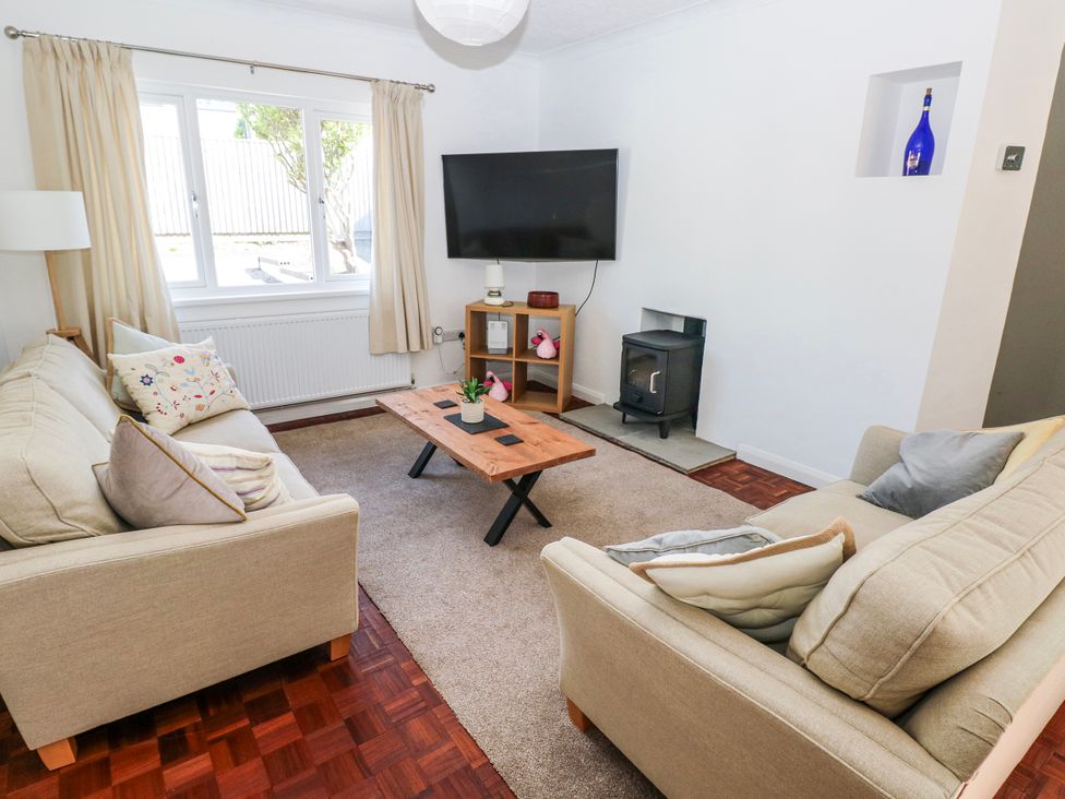 A living room with a sofa, coffee table, and television at Moonraker, Saundersfoot