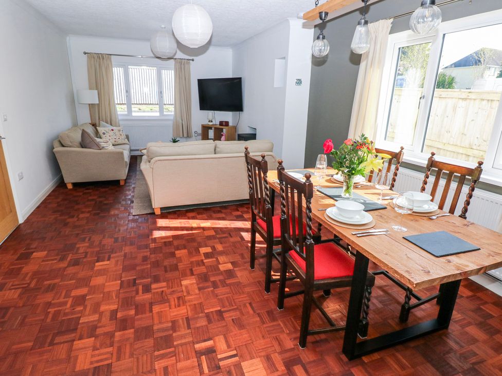A living room with a sofa and dining area at Moonraker in Saundersfoot