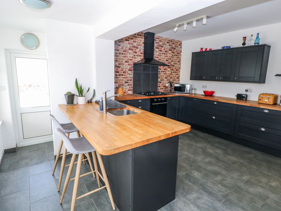 A kitchen with wooden countertops and modern appliances at Moonraker in Saundersfoot