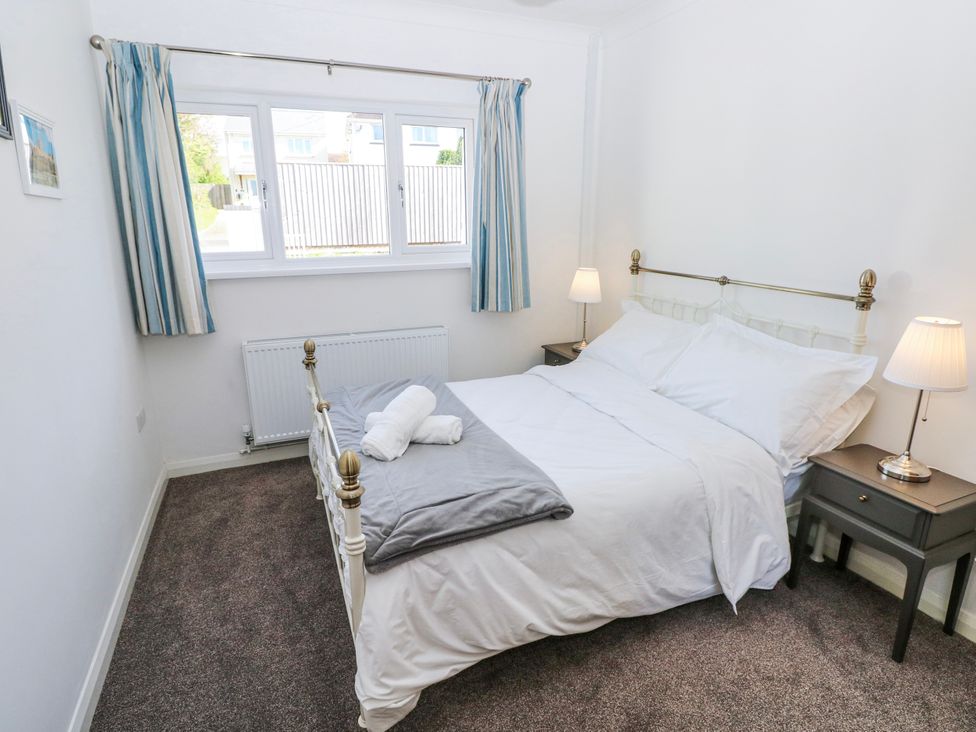 A bedroom with a bed and nightstand at Moonraker in Saundersfoot