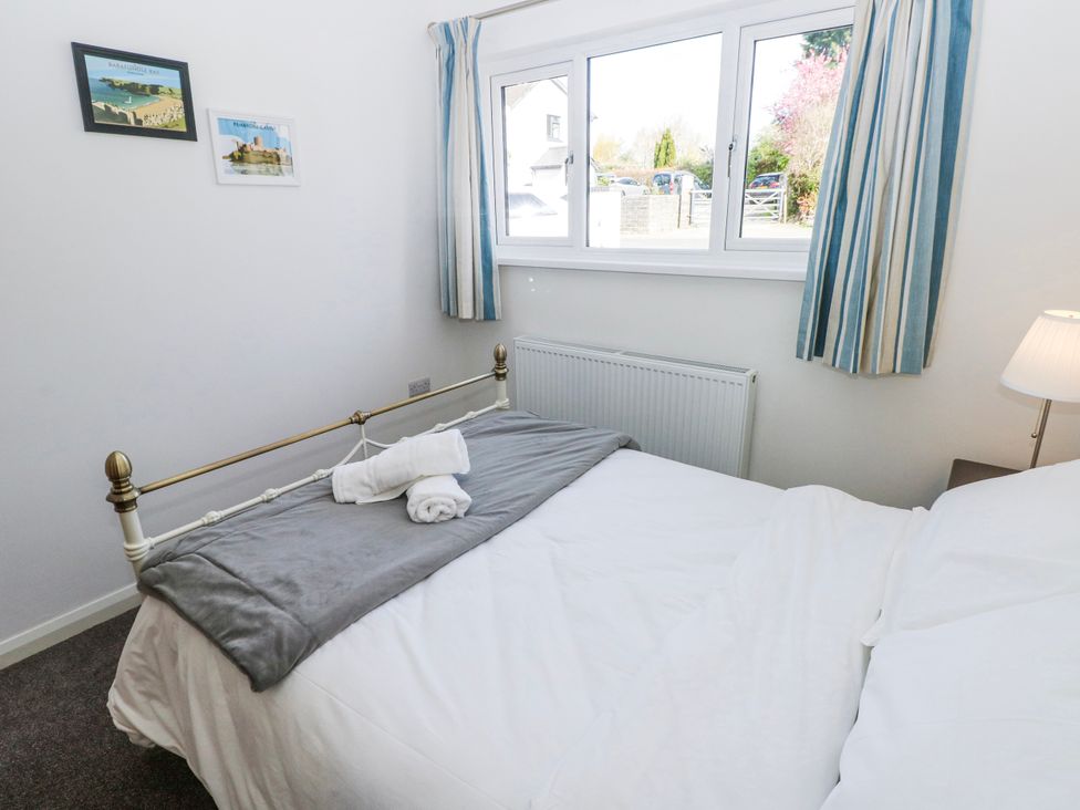 A bedroom with a bed and window at Moonraker in Saundersfoot