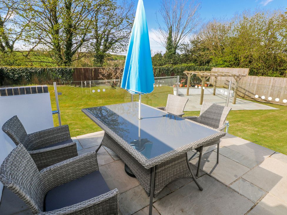 A dining area with a table and umbrella at Moonraker in Saundersfoot