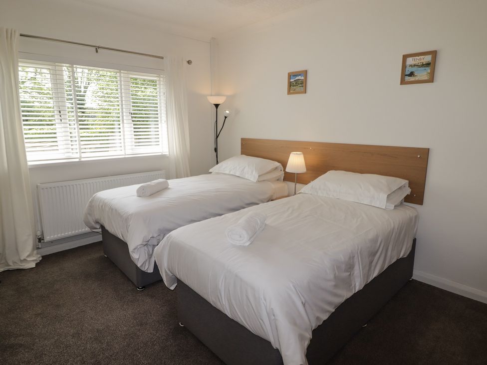 A bedroom with twin beds and a lamp at Moonraker in Saundersfoot