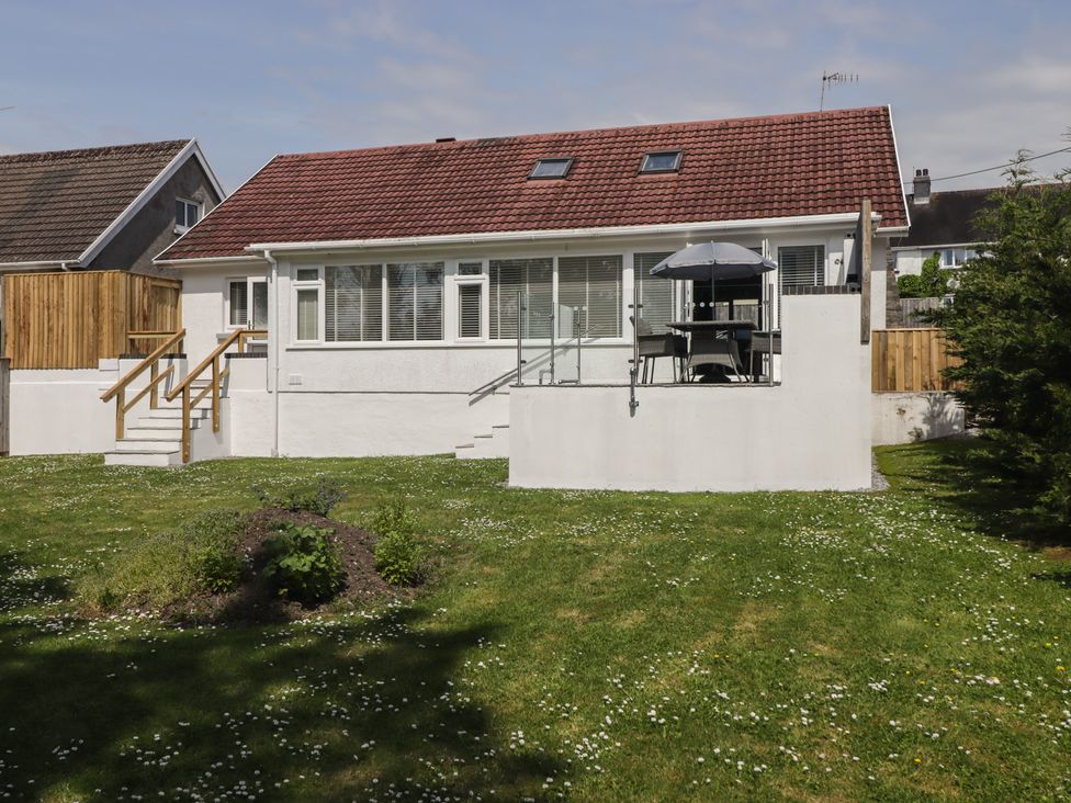A house with stairs and a deck in the garden at Moonraker in Saundersfoot