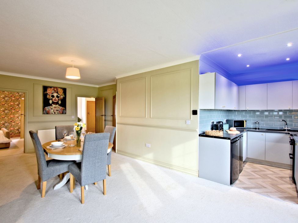 A dining room with a table and kitchen appliances at River View Cottage in Hanlith near Malham